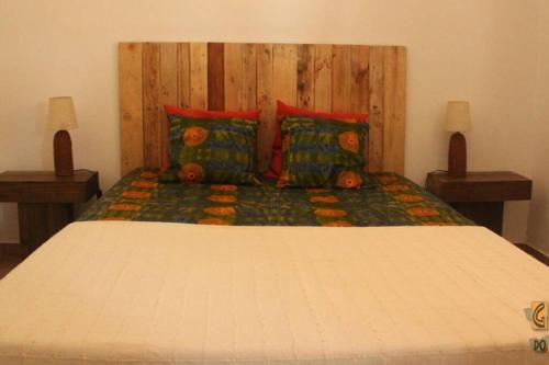 a bedroom with a large bed with red pillows at Gosto do Campo in Lavre