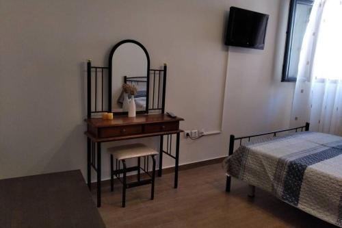 a bedroom with a desk with a mirror and a bed at Ευχάριστο σπίτι στην χώρα Κύθνου in Kithnos