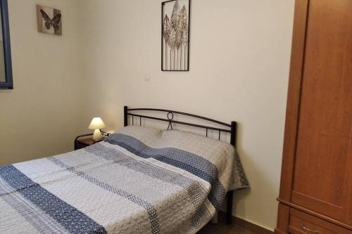 a bedroom with a bed with a blue and white blanket at Ευχάριστο σπίτι στην χώρα Κύθνου in Kithnos