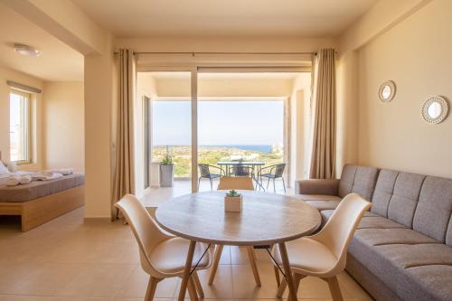 un soggiorno con tavolo e divano di Cretan fleur apartments a Elafonisi