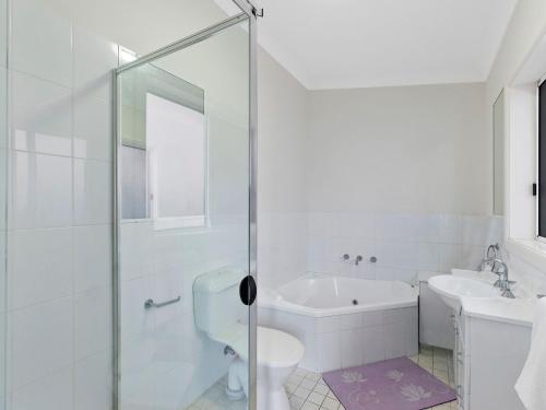 Un baño con ducha, inodoro y lavabo. en Surfside Palms 14, en The Entrance