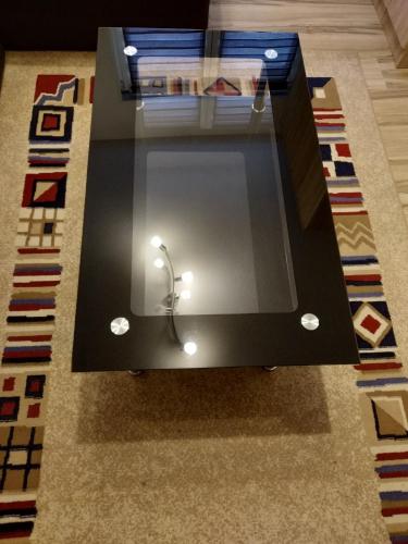 a coffee table with a glass top on a rug at Guest House RG in Žabljak