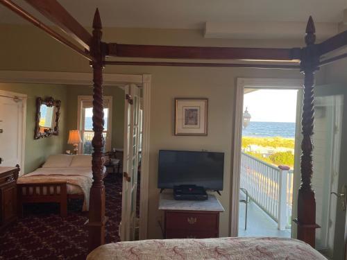 um quarto com uma cama, uma televisão e uma varanda em Laingdon Hotel em Ocean Grove