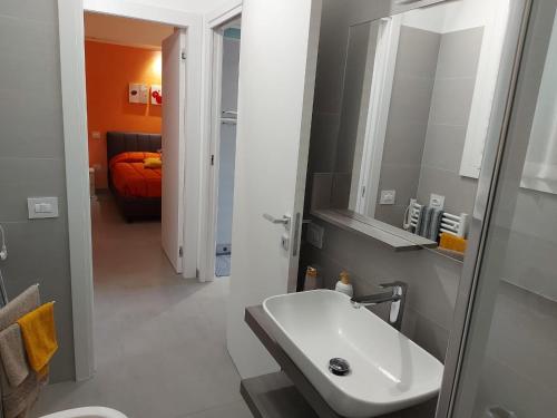 ein Bad mit einem Waschbecken und einem Spiegel in der Unterkunft Coru e Bentu in Quartu SantʼElena