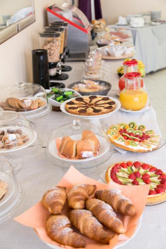 a buffet of food on a table with plates of food at Hotel Fidenza in Fidenza
