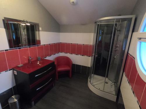 勒托利的住宿－Le Flocon Vosgien，红色的浴室设有淋浴和盥洗盆。