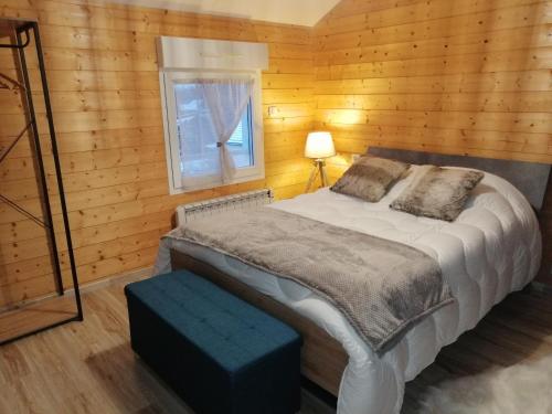 勒托利的住宿－Le Flocon Vosgien，木制客房的一张床位,设有窗户