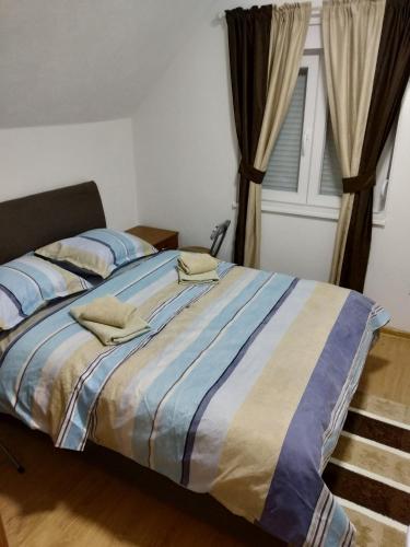 a bedroom with a large bed with blue and white sheets at Guest House RG in Žabljak