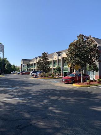 an empty street in front of a building with cars at Super 8 in Stafford