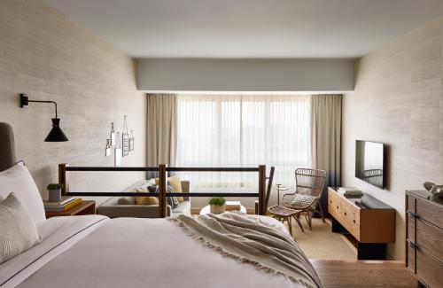a bedroom with a bed and a desk and a room at Gurney's Montauk Resort & Seawater Spa in Montauk