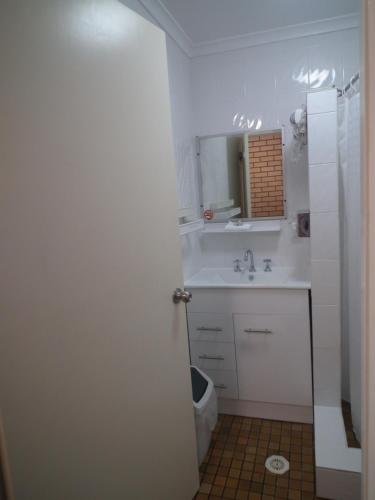 a white bathroom with a sink and a mirror at Bega Southtown Motor Inn in Bega