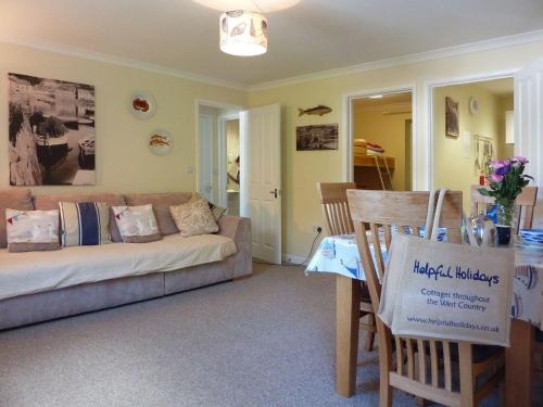 a living room with a couch and a table at Stones Throw in Saint Mawes