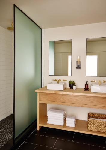 a bathroom with two sinks and two mirrors at Gurney's Montauk Resort & Seawater Spa in Montauk