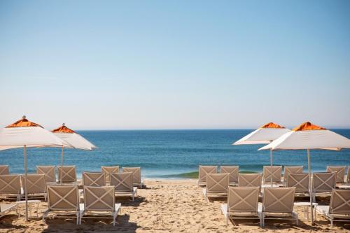 a group of chairs and umbrellas on a beach at Gurney's Montauk Resort & Seawater Spa in Montauk