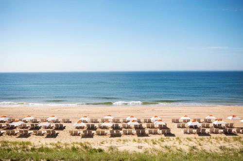 a group of chairs and umbrellas on a beach at Gurney's Montauk Resort & Seawater Spa in Montauk