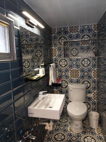 a bathroom with a toilet and a sink at Fun Sun B&B in Magong