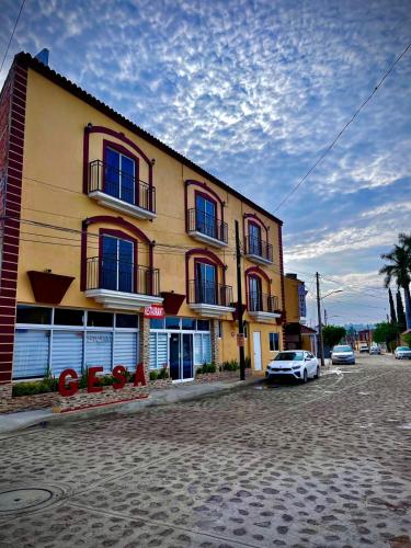 a yellow building with a car parked in front of it at Hotel Gesa in Villa Corona