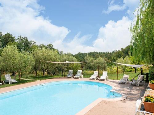 a swimming pool with chaise lounges and chairs at Apartment in Collesalvetti near Pisa in Guasticce