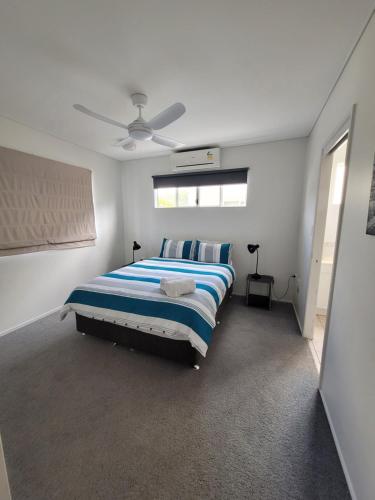 - une chambre avec un lit et un ventilateur de plafond dans l'établissement Blue horizon, à Yeppoon