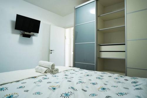 um quarto com uma cama e uma TV na parede em Sea view apartment em Bat Yam