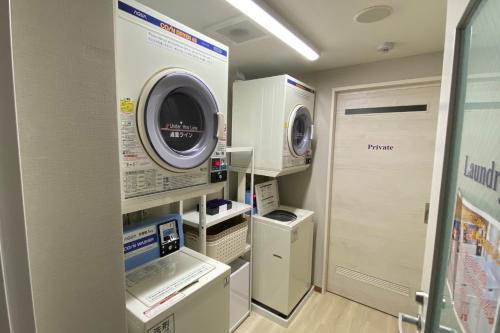 a laundry room with a washer and dryer at Hotel Grandolce HAKATA in Fukuoka
