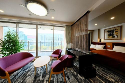 福岡市にあるホテルグランドルチェ博多のベッドと大きな窓が備わるホテルルームです。