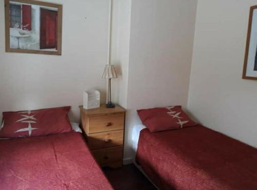 a bedroom with two beds and a night stand with a lamp at 61 in Winchester