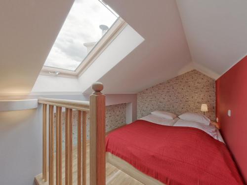 クラクフにあるBeauty of Krakow Apartmentの屋根裏のベッドルーム(赤い毛布付きのベッド付)