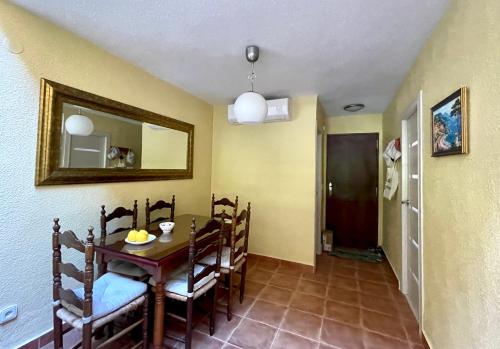a dining room with a table and chairs and a mirror at Holiday home del Cabo in Playas de Orihuela