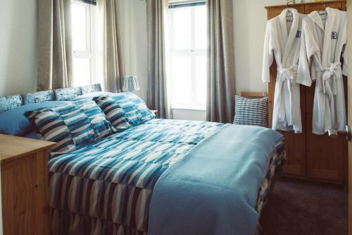 a bedroom with a bed with blue and white sheets at Rock Quay in Killyleagh