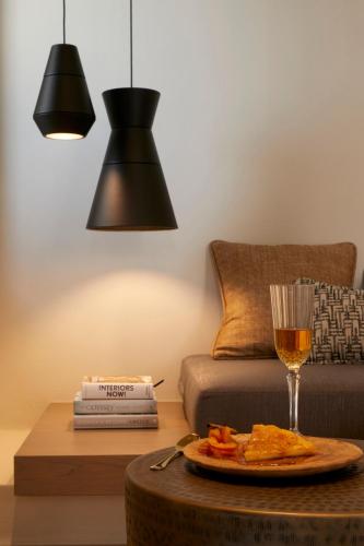 a table with a plate of food and a glass of wine at Halcyon Days Suites in Pirgos
