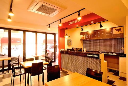 un restaurant avec des tables et des chaises ainsi qu'un bar dans l'établissement Red Guesthouse, à Séoul