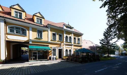 a large yellow building with a store on a street at Gasthof zum Schilling in Lackenbach