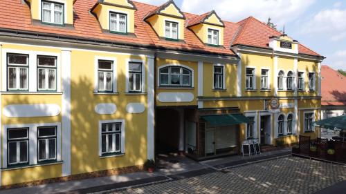 a yellow building with a red roof at Gasthof zum Schilling in Lackenbach