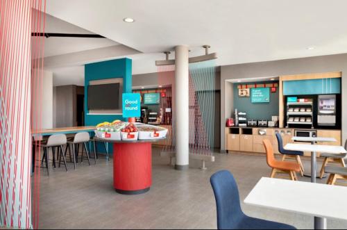 a restaurant with a cafeteria with tables and chairs at AVID Hotels Corpus Christi - Portland, an IHG Hotel in Portland