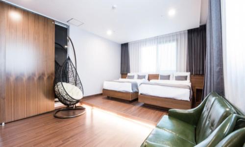 a room with two beds and a television and a couch at Silla Boutique Hotel Premium in Gyeongju