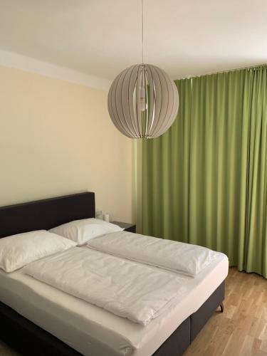 a bedroom with a large bed with a green curtain at Gasthof zum Schilling in Lackenbach