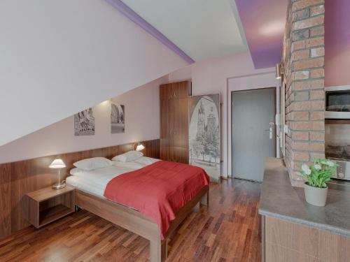 ein Schlafzimmer mit einem Bett mit einer roten Decke in der Unterkunft Beauty of Krakow Studio in Krakau