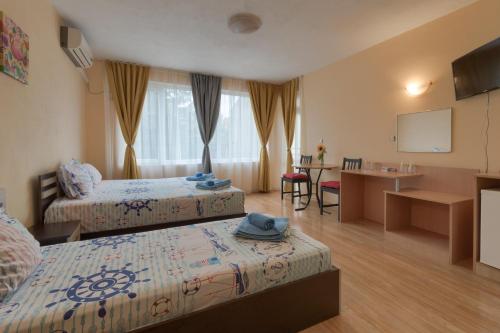 Habitación de hotel con 2 camas y mesa en Kazlarov Guest House, en Kiten