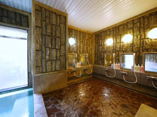 een badkamer met houten wanden, wastafels en spiegels bij Hotel Route-Inn Nagaizumi Numazu Inter 2 in Nagaizumi