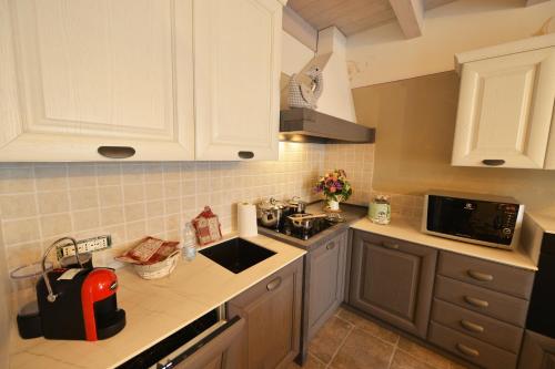 a kitchen with white cabinets and a counter top at La Beppa - Casa Vacanza in Pontremoli