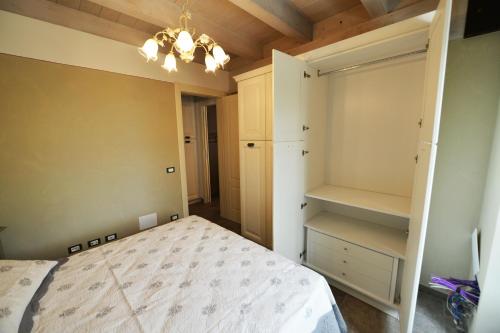 a bedroom with a bed and a closet and a chandelier at La Beppa - Casa Vacanza in Pontremoli