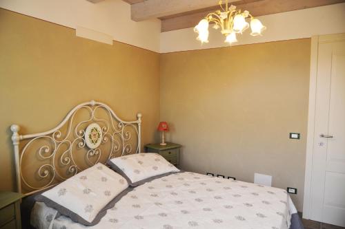 a bedroom with a bed and a chandelier at La Beppa - Casa Vacanza in Pontremoli