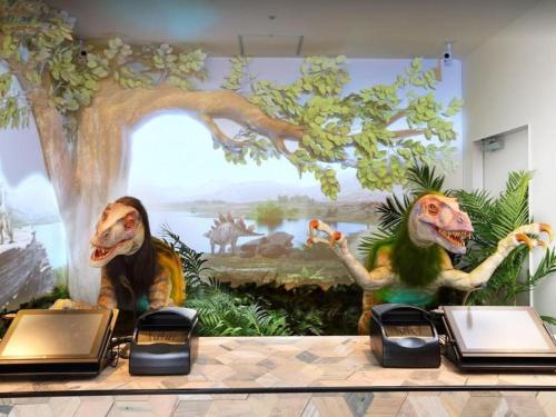 a mural of dinosaurs on the wall of a room at Henn na Hotel Osaka Shinsaibashi in Osaka