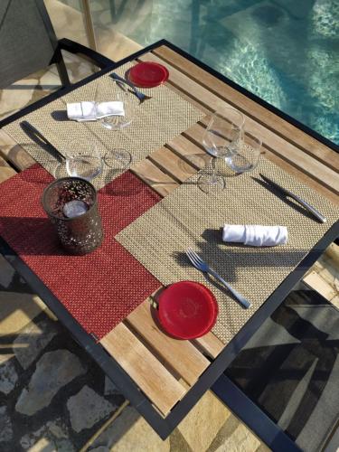 a table with red plates and wine glasses on it at Auberge Du Roua in Argelès-sur-Mer