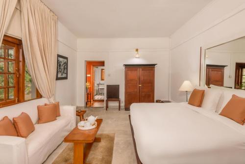 a bedroom with a large white bed and a couch at Jetwing Warwick Gardens, A Luxury Reserve in Nuwara Eliya