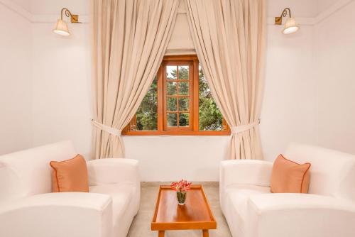 a living room with two white couches and a window at Jetwing Warwick Gardens, A Luxury Reserve in Nuwara Eliya