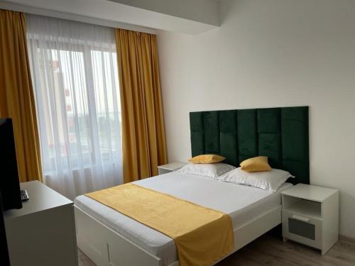 a bedroom with a large bed with a green headboard at Perfect Spot Summerland Mamaia in Mamaia
