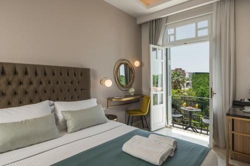 a bedroom with a large bed and a balcony at Plaza 1866 Superior City Rooms in Chania Town