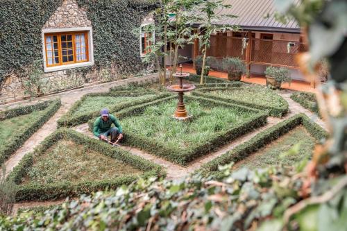 a man squatting in the middle of a garden at Jetwing Warwick Gardens, A Luxury Reserve in Nuwara Eliya